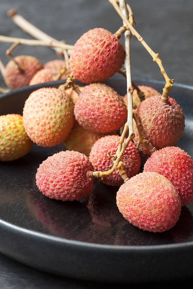 Fresh lychees on a black plate