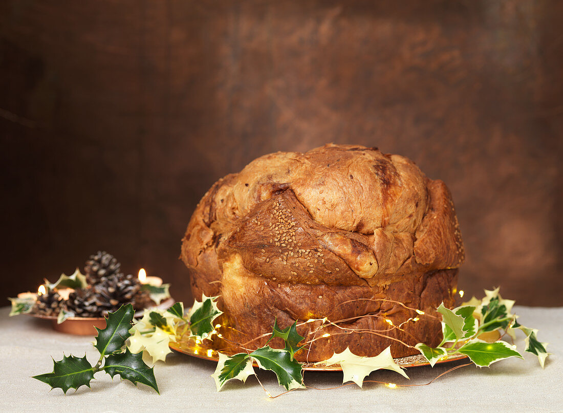 Panettone with holly twigs on a cake plate