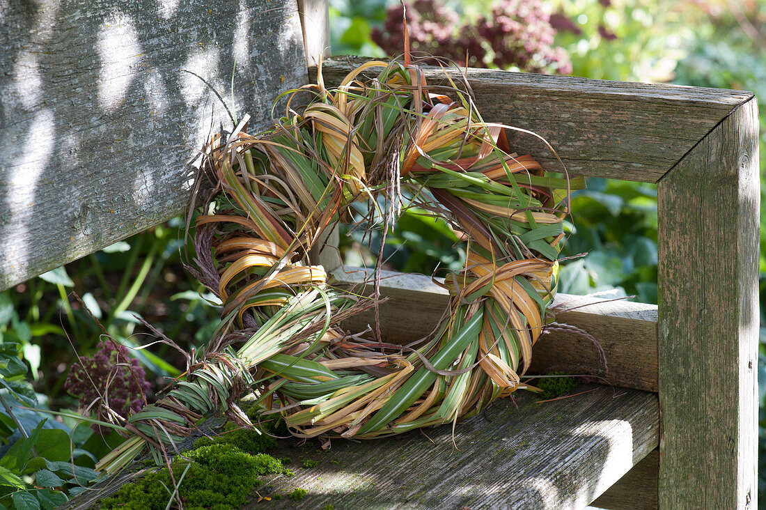 Autumn wreath made of Chinese silver grass on the garden bench