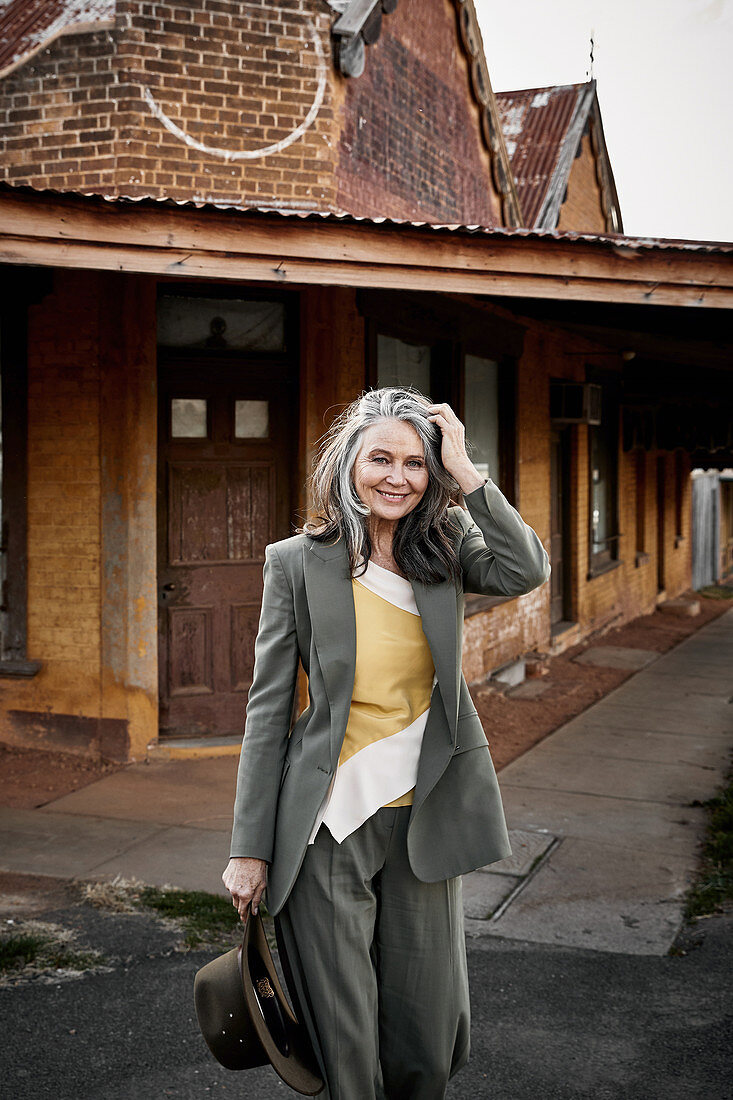 A grey-haired woman wearing a grey trouser suit