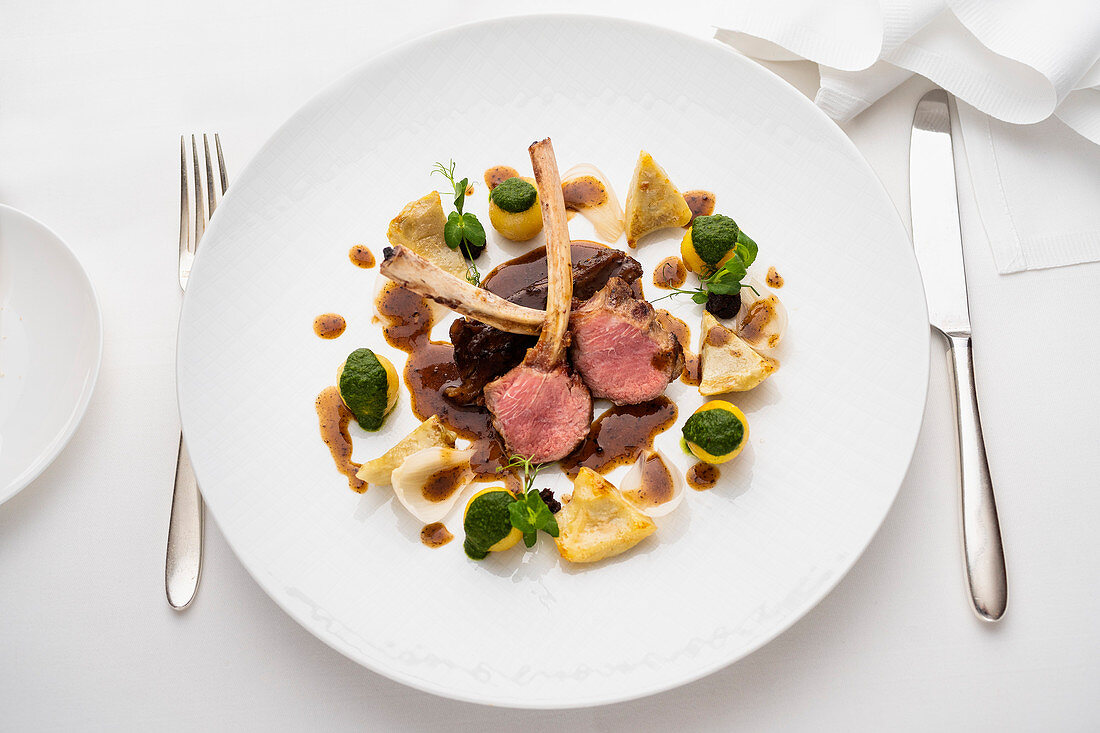 Lamb saddle and chops with artichokes, Paris potatoes and truffle jus