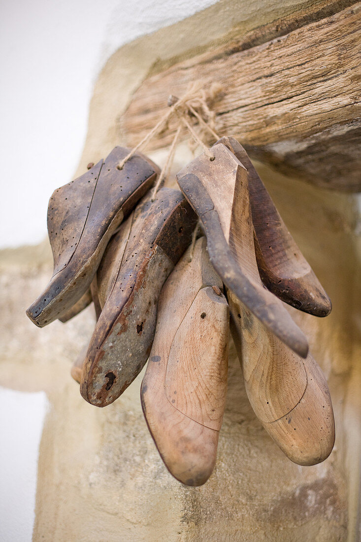 Old cobbler's moldings hanging from a rustic wooden beam