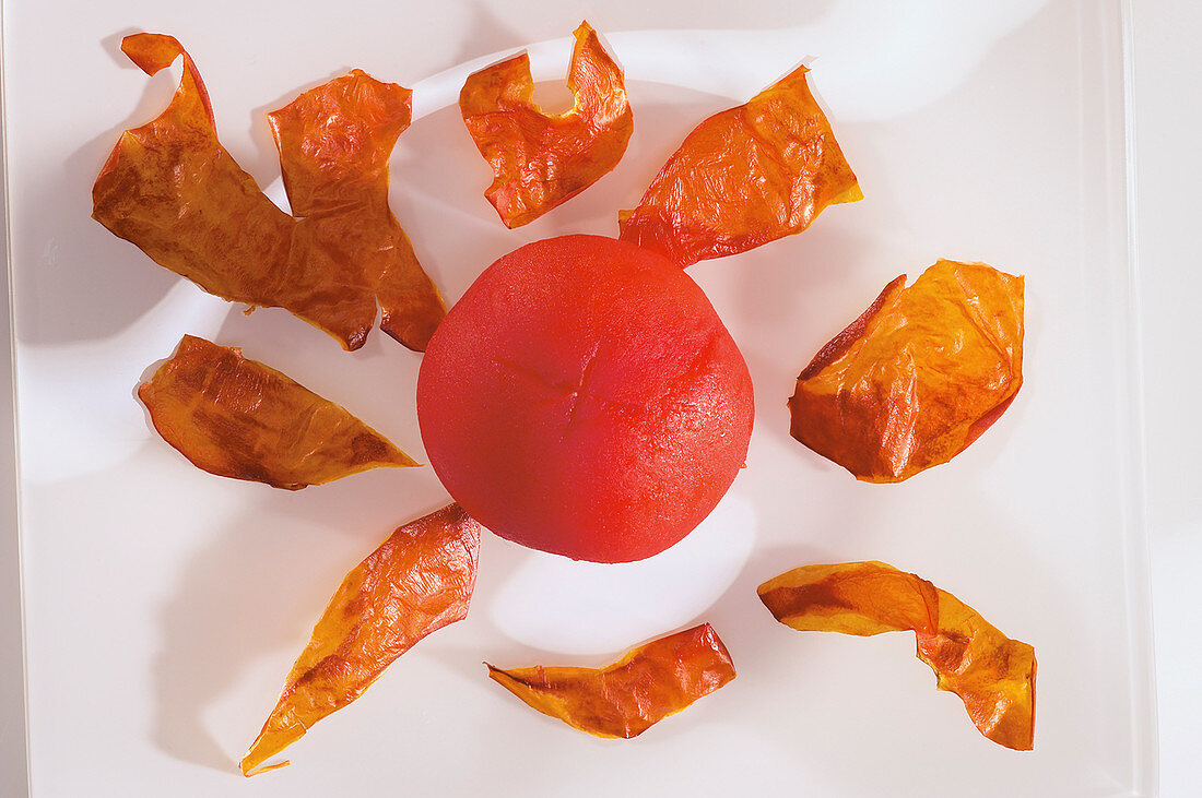 Getrocknete Tomatenhaut neben gehäuteter Tomate