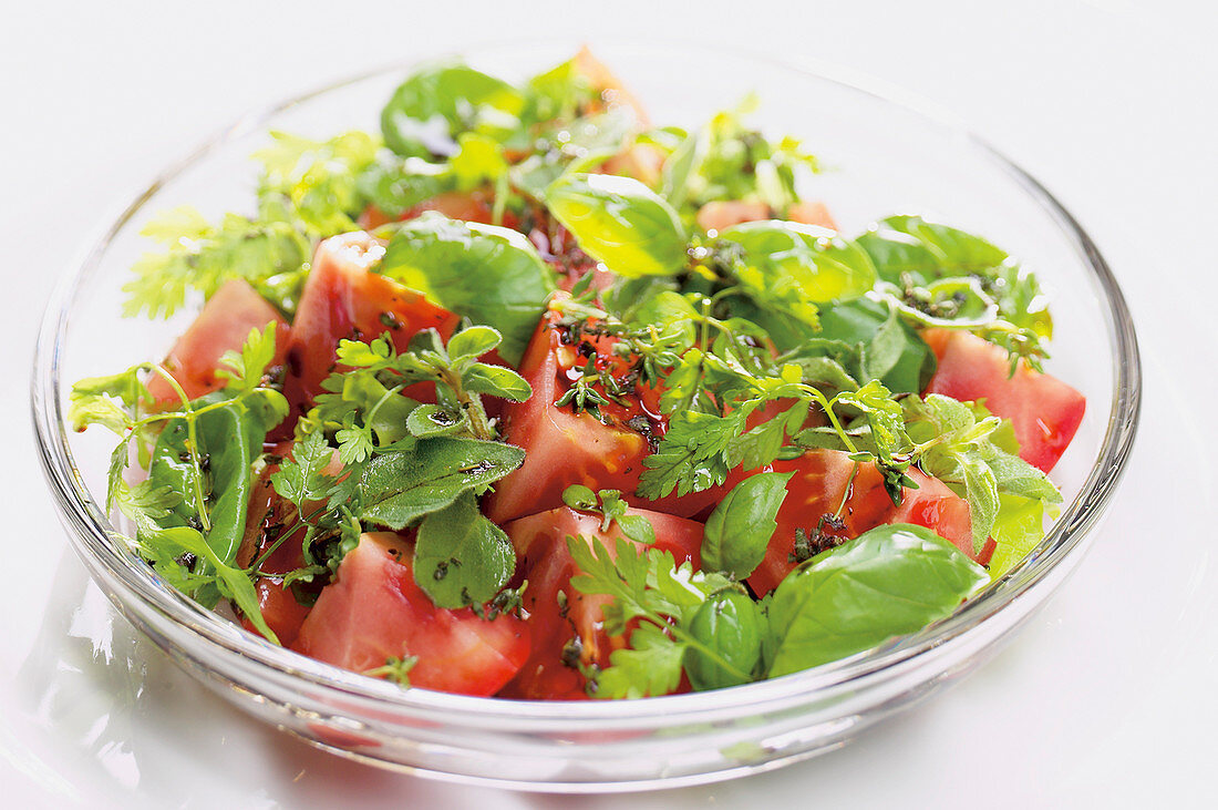 Tomato salad with herbs on a glass plate