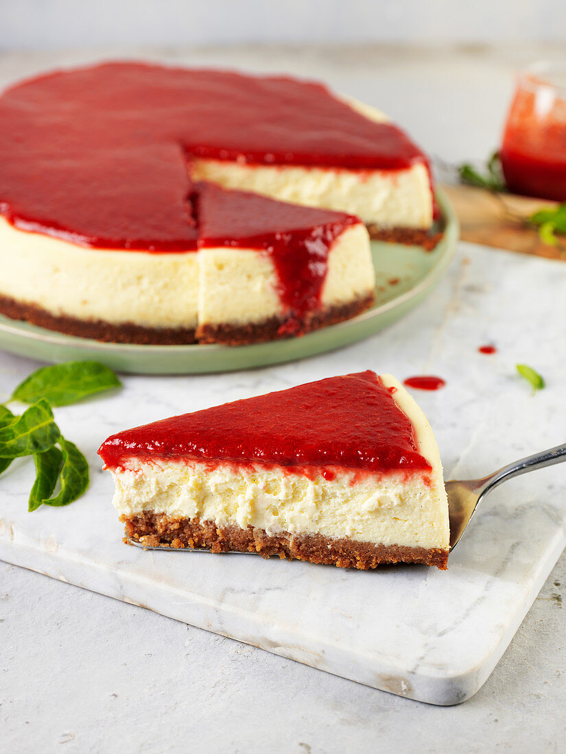 New York Cheesecake mit Erdbeersauce, angeschnitten