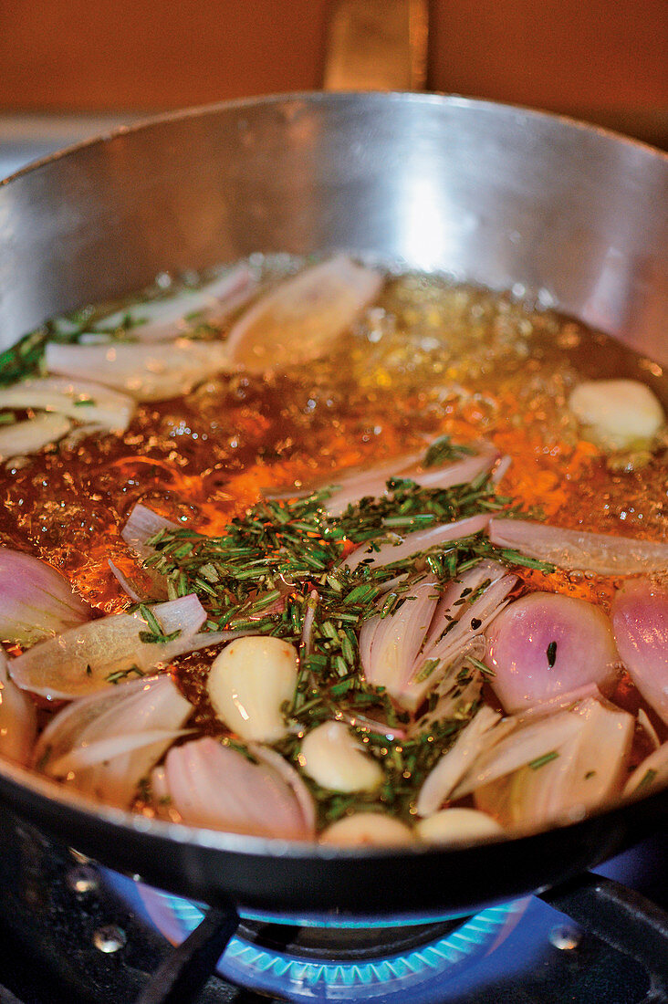 Wurstherstellung: Schalotten und Knoblauch in Brühe kochen