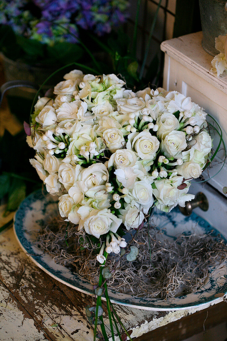 Heart-shaped arrangement of white roses and bouvardia