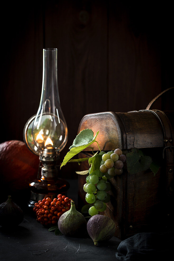 Autumn still life with fruits, a wooden box and a kerosene lamp