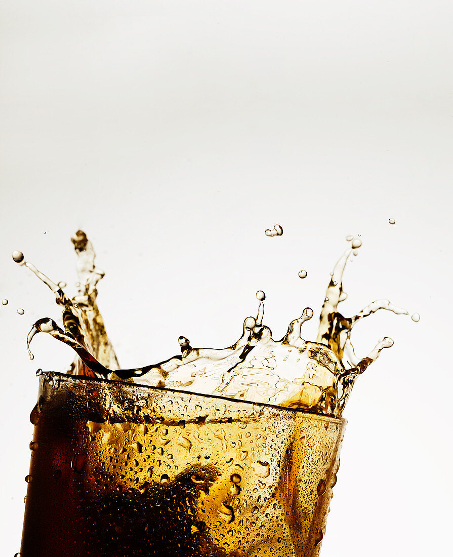 A glass of cola with a splash