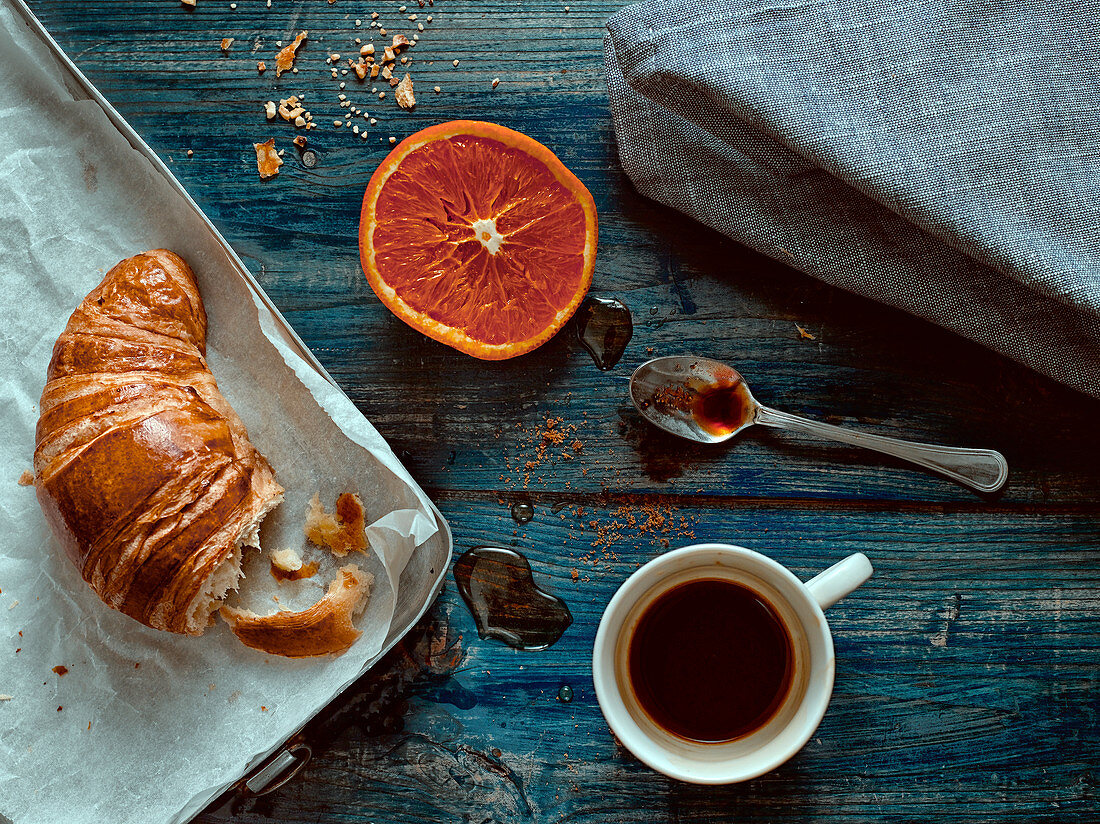 Italian breakfast at home with croissant, espresso and orange