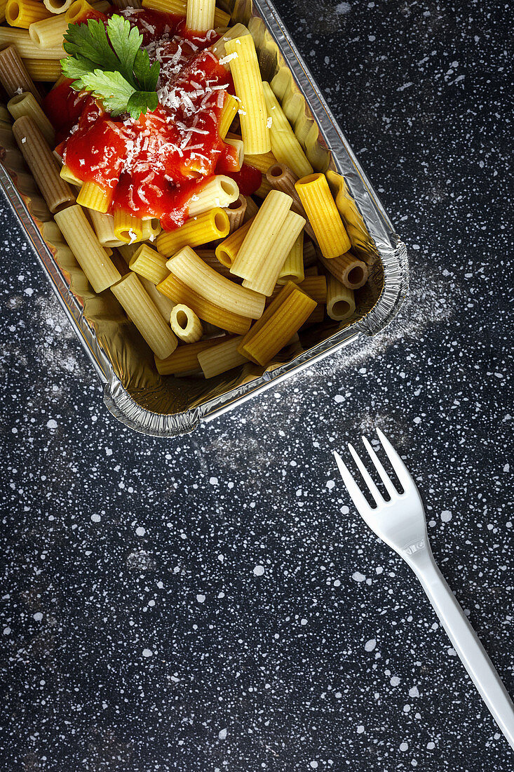 Macaroni with ketchup and cheese in container for takeaway