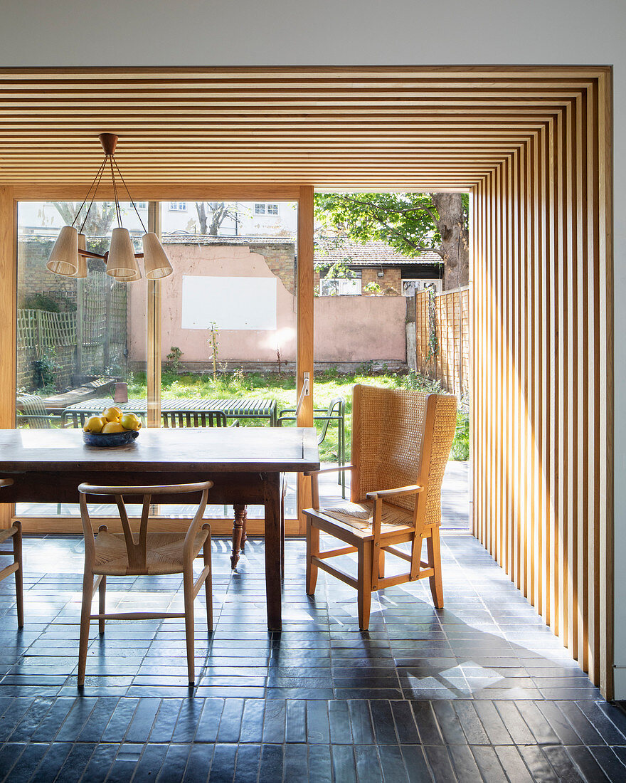 Wood-clad walls and ceiling in dining area of open-plan interior