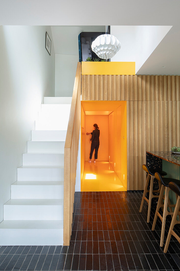 Staircase in open-plan interior with black tiled floor