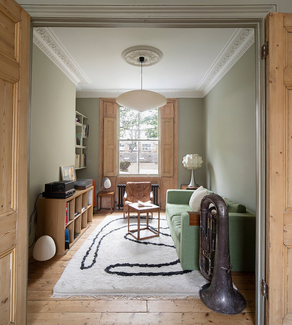 Living room in period building with stucco elements and pale green walls