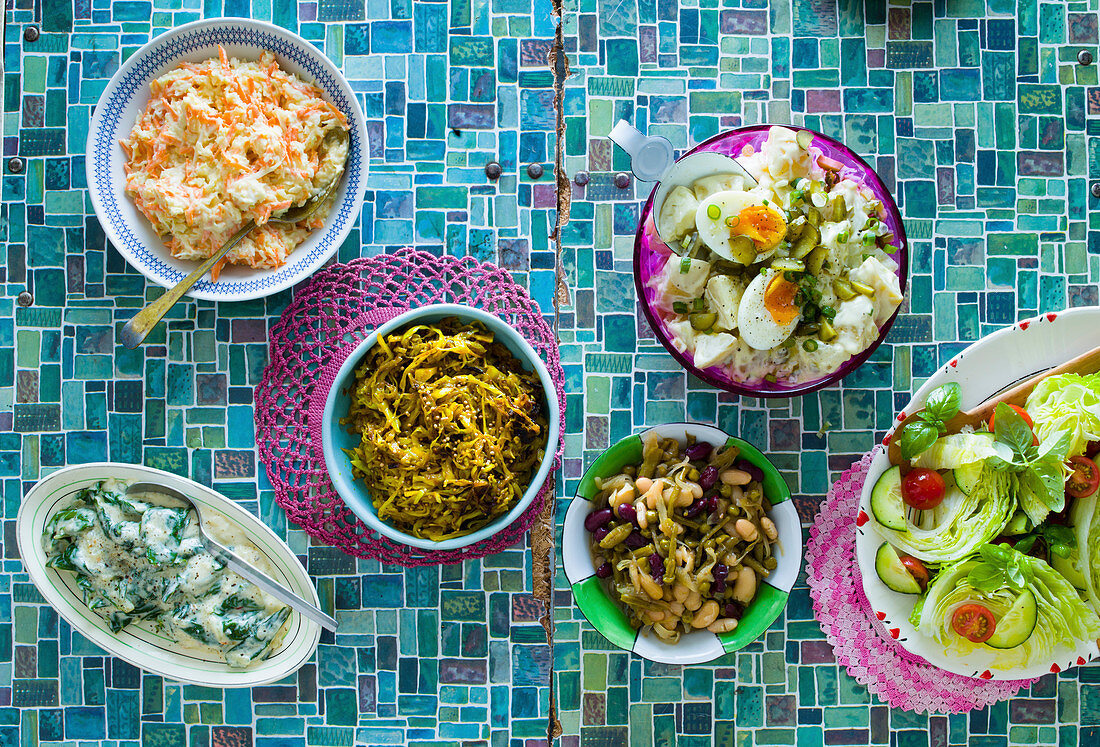 Afrikanische Salate: Coleslaw, Currykohl, Kartoffelsalat, Morogo (wilder Spinat), grüner Salat und Bohnensalat