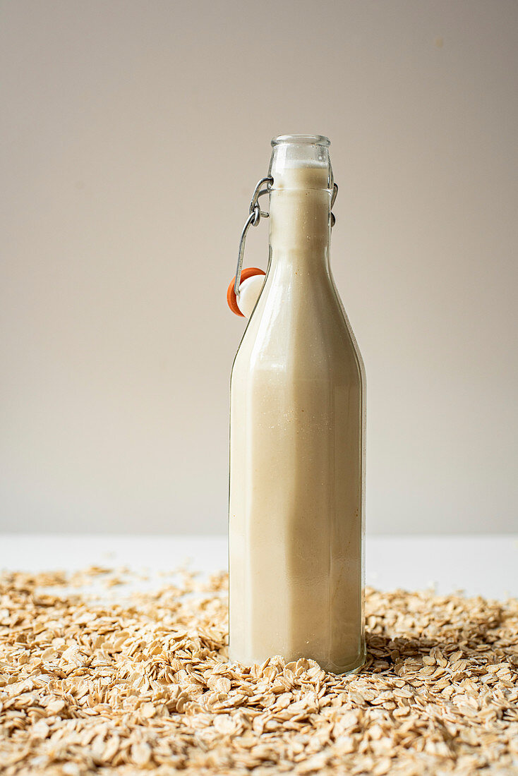 Haferdrink in Flasche auf Haferflocken