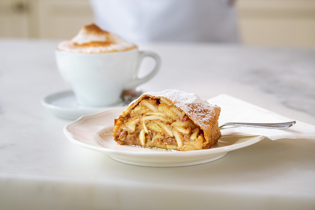 A slice of apple strudel and a cup of coffee