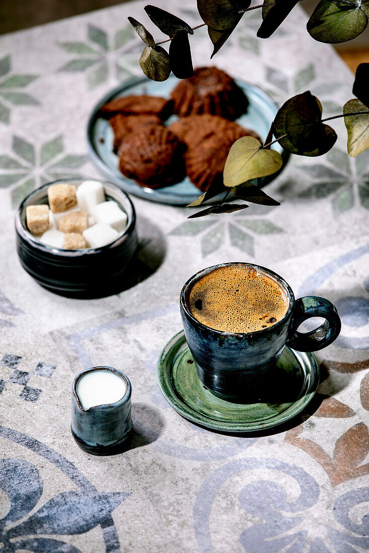 Cup of turkish black coffee with milk, sugar cubes and cookies