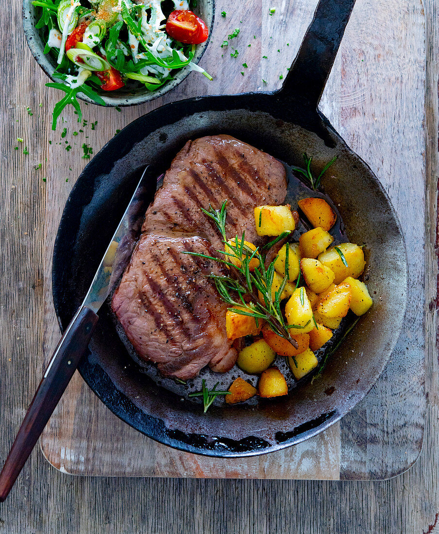 Rump steak with rosemary potatoes in a pan