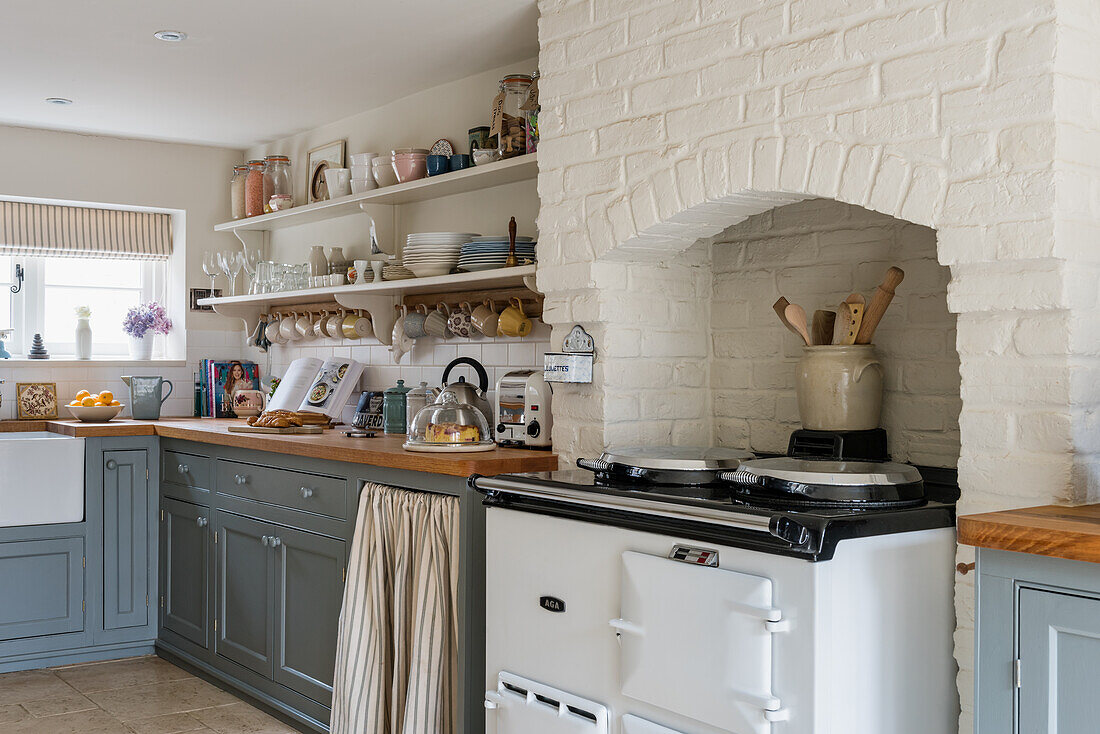 Aga cooker in brick niche in country-house kitchen