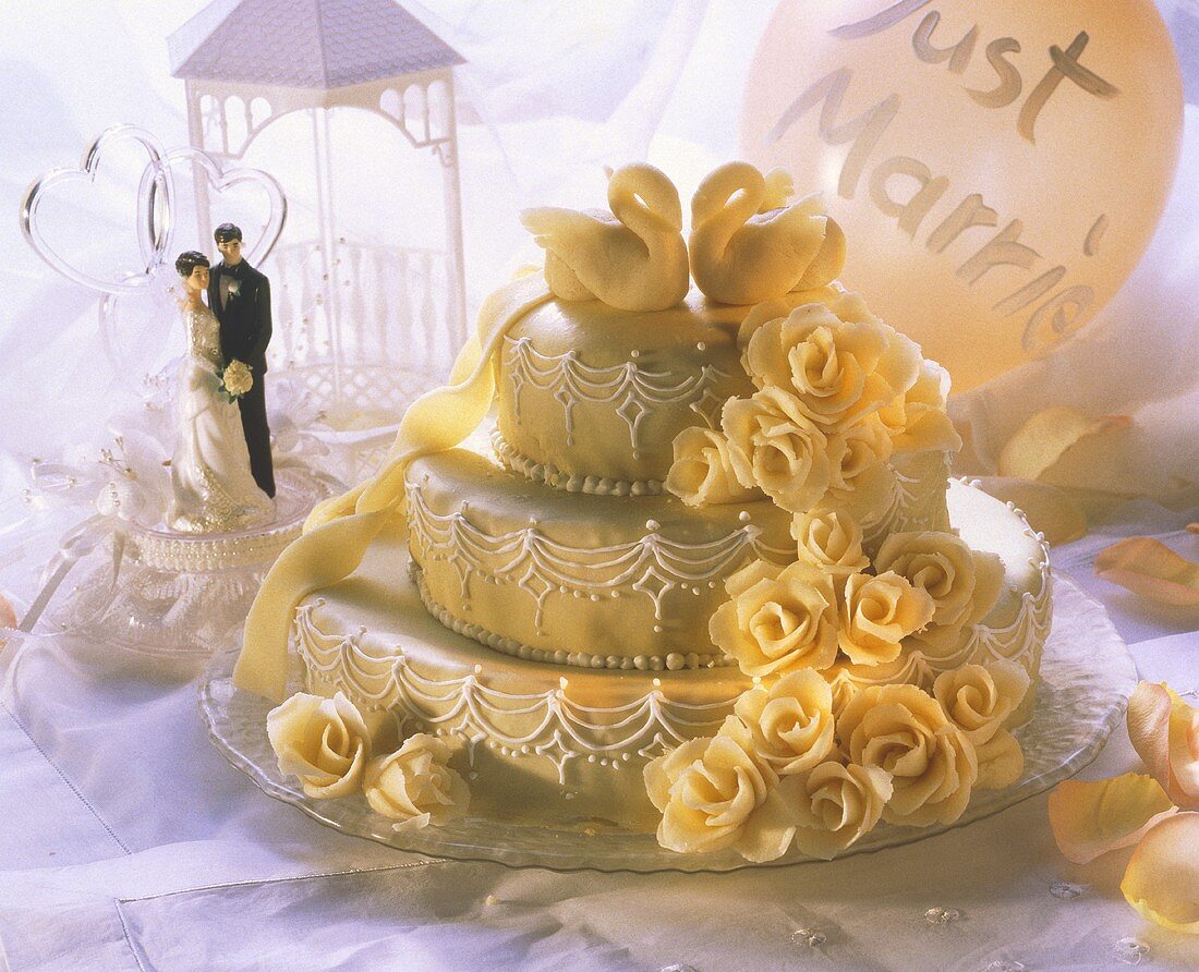 Three-tiered wedding cake with marzipan roses and swans