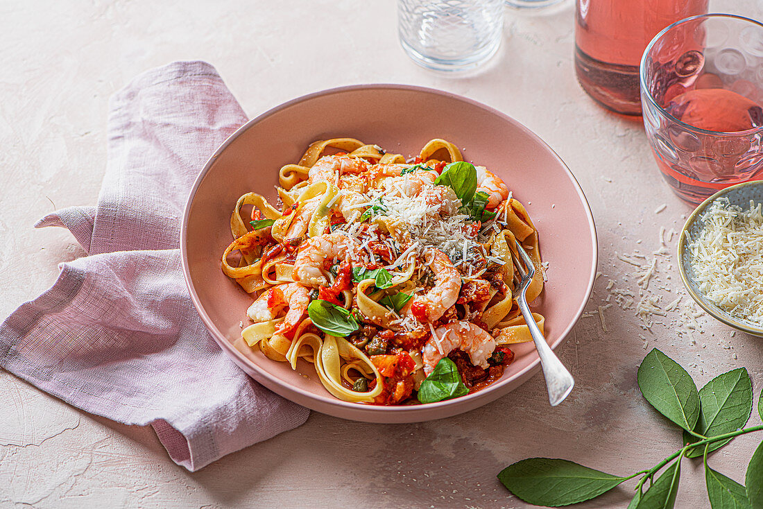 Pasta putanesca with tomato, anchovies, garlic sauce and garlic prawns