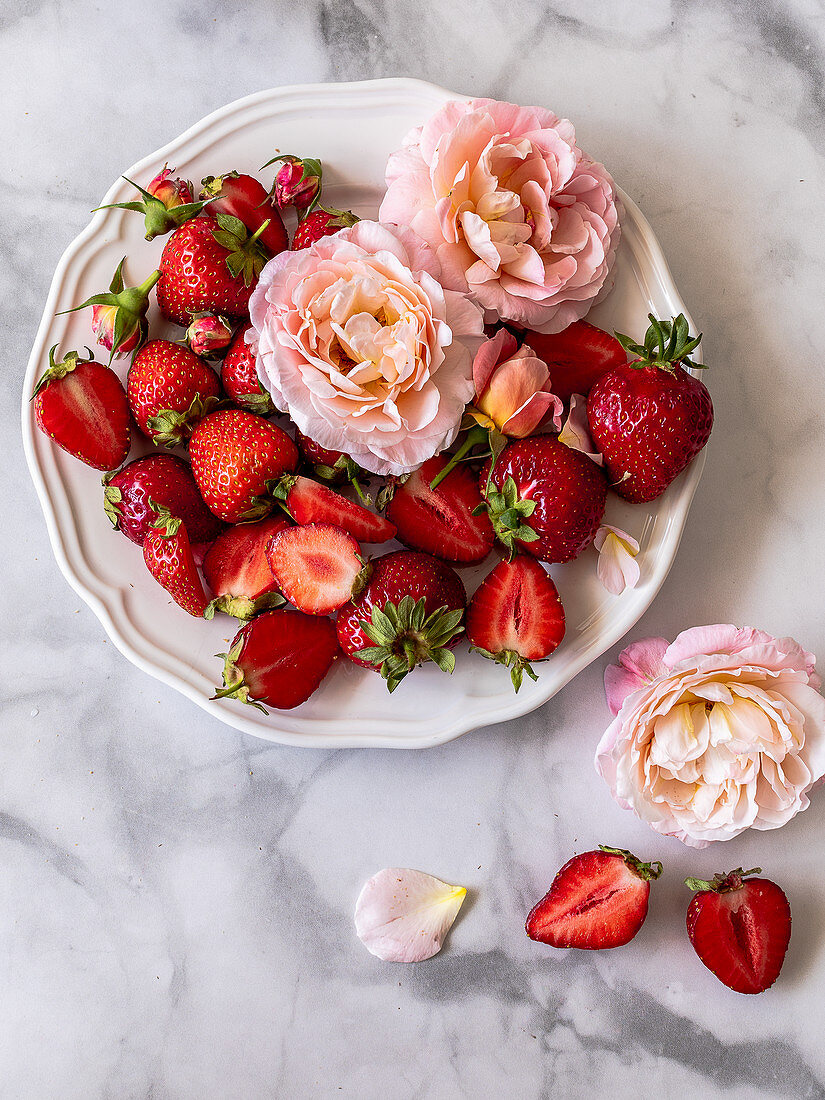 Erdbeeren und Rosen auf Teller
