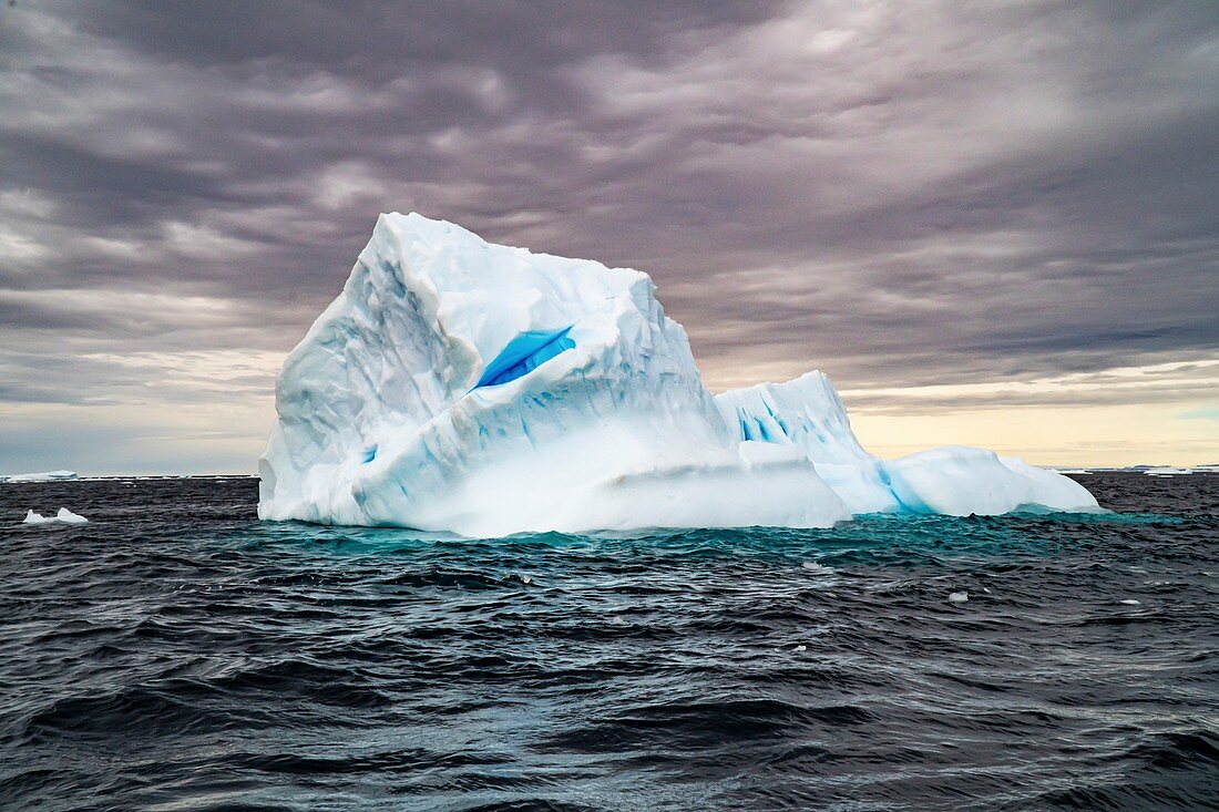 Melting iceberg with ice floes