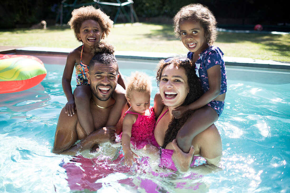 Portrait excited family playing in summer swimming pool