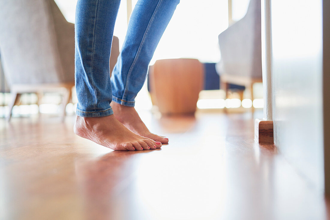 Close up bare feet of woman on hardwood floor