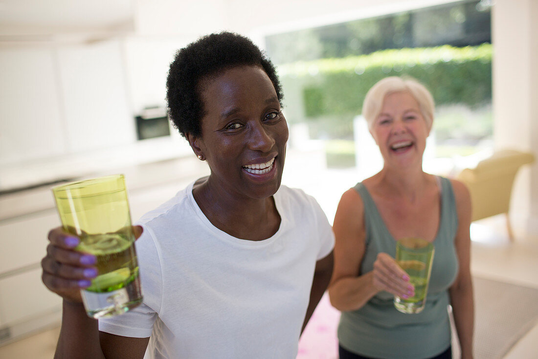Portrait senior women friends drinking water after workout