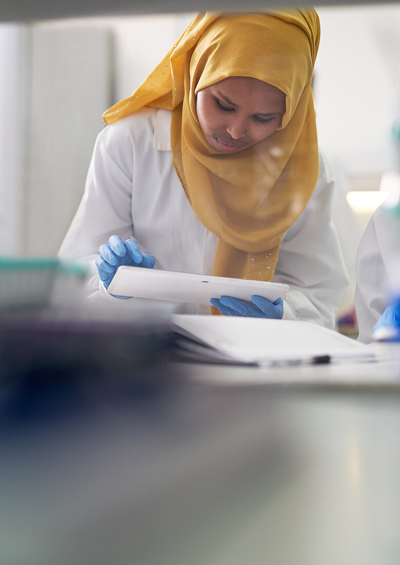 Scientist in hijab using digital tablet