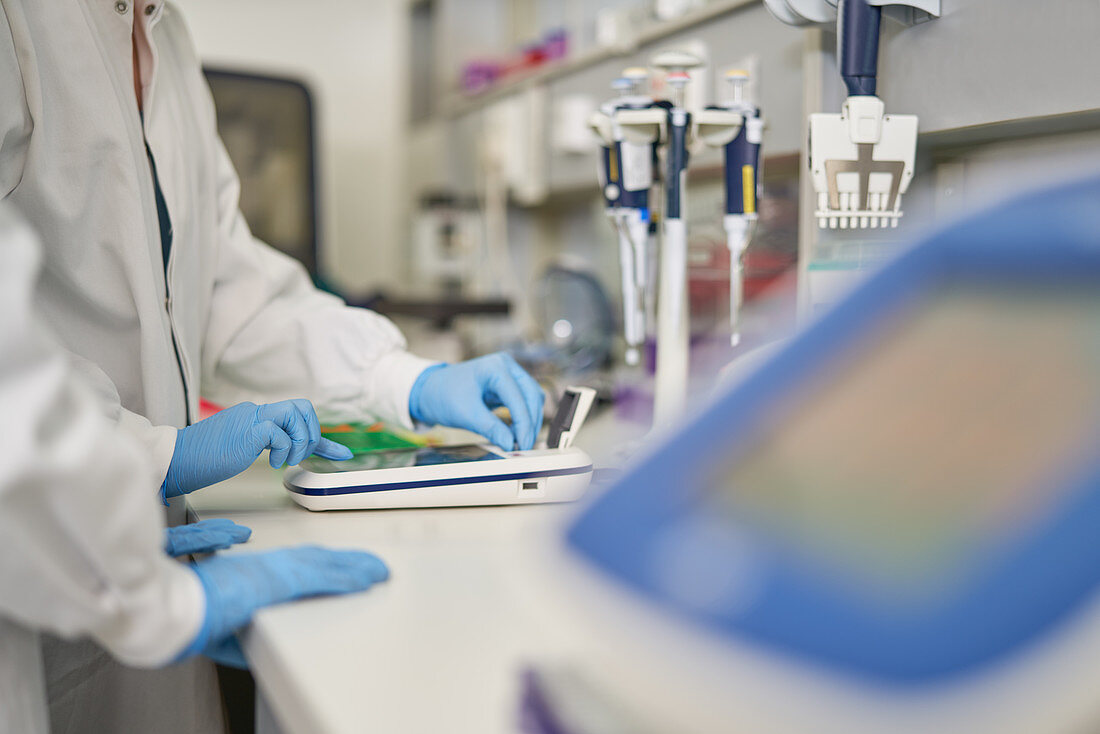 Scientists in rubber gloves using equipment in laboratory