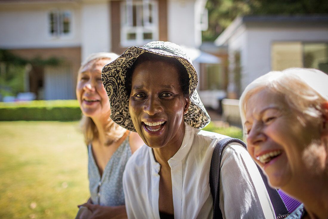 Portrait happy senior women friends in summer backyard