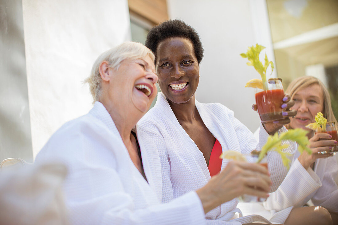 Senior women friends enjoying bloody mary cocktails