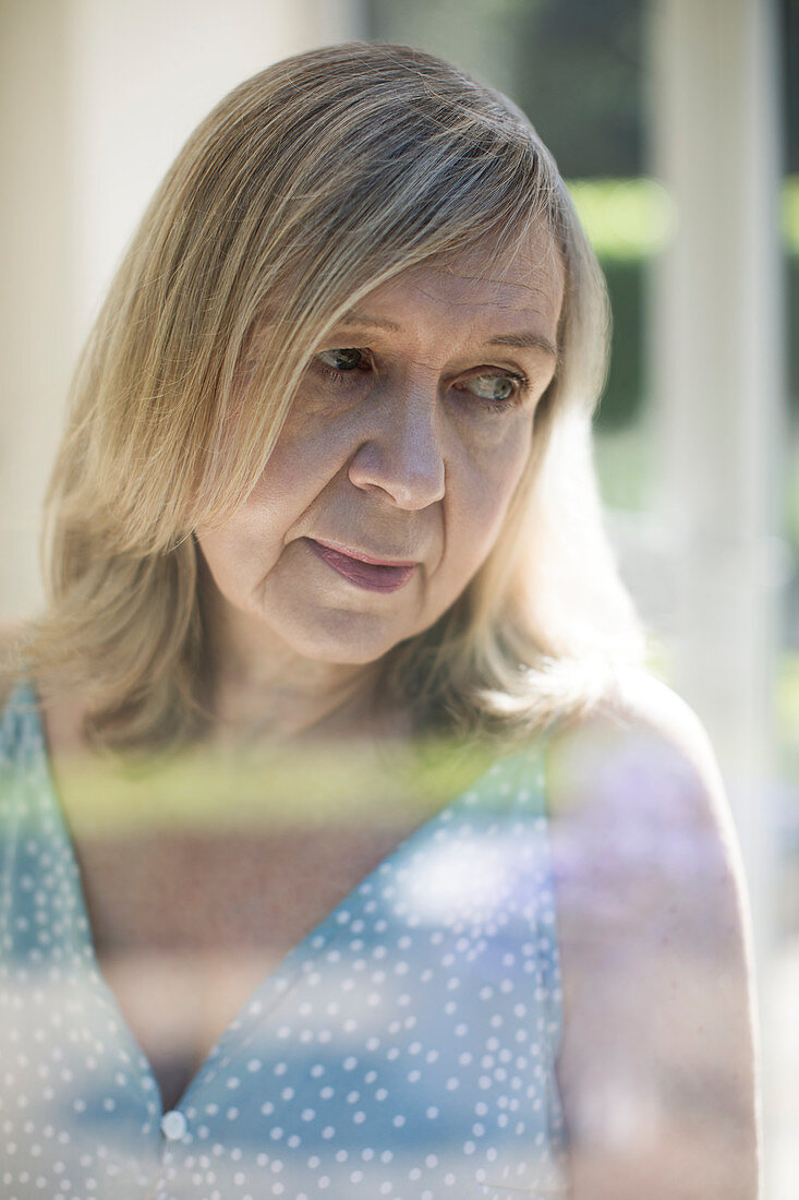 Thoughtful senior woman looking over shoulder