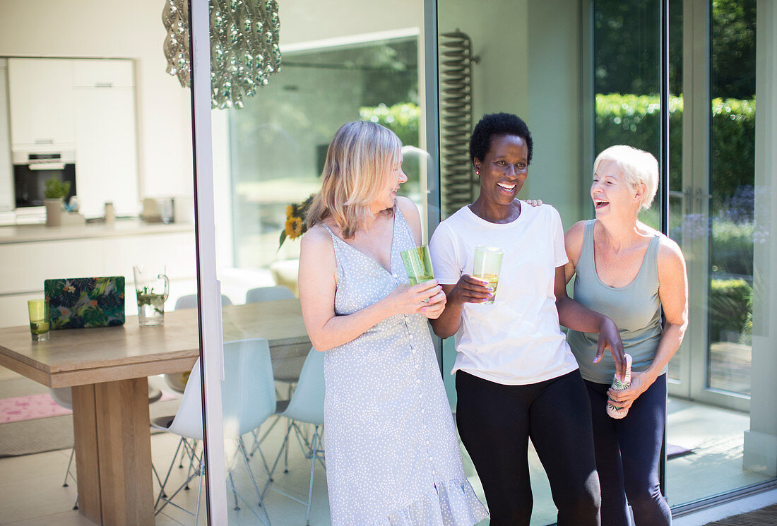 Senior women friends drinking and laughing on patio
