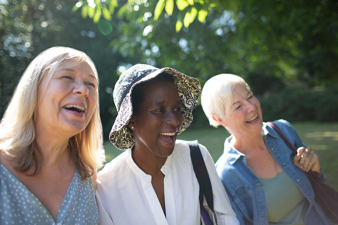 Happy senior women friends laughing in summer garden