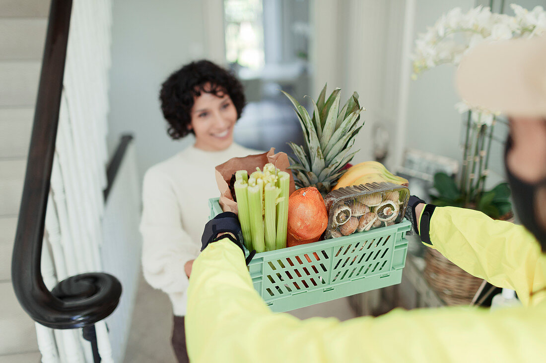 Grateful woman receiving grocery delivery at home