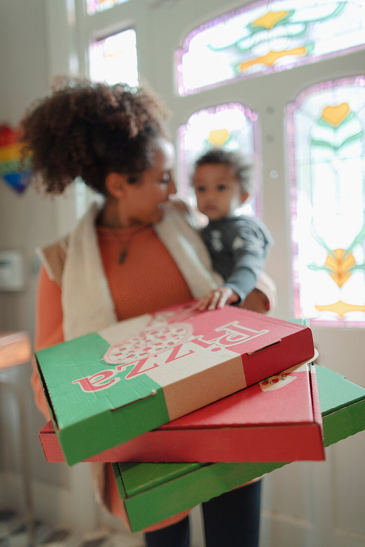 Mother and baby daughter receiving pizza delivery