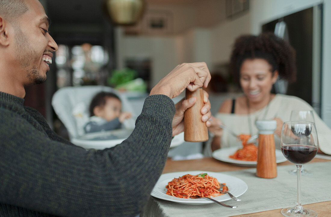 Happy family enjoying spaghetti dinner at dining table