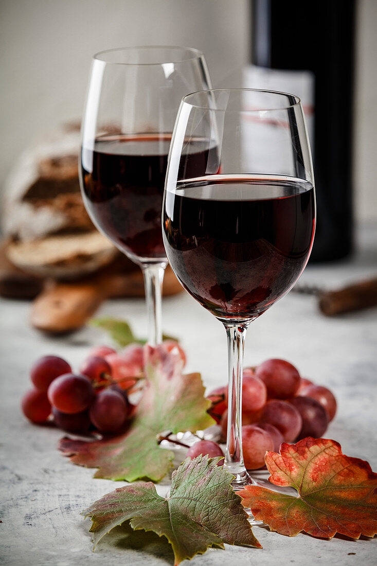 Two glasses of red wine, grapes and leaves
