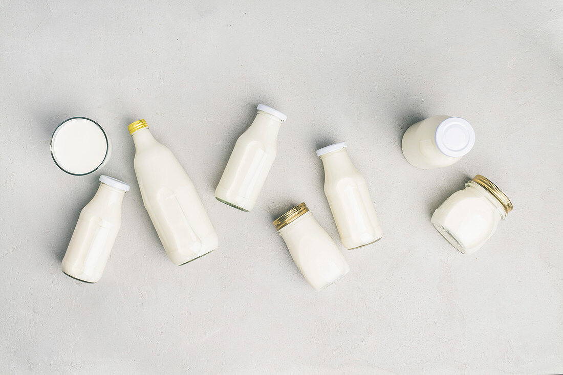 Various bottles of milk on grey background