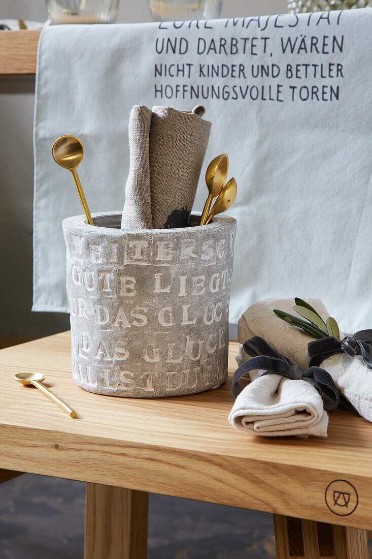 Embossed writing on clay pot holding kitchen utensils