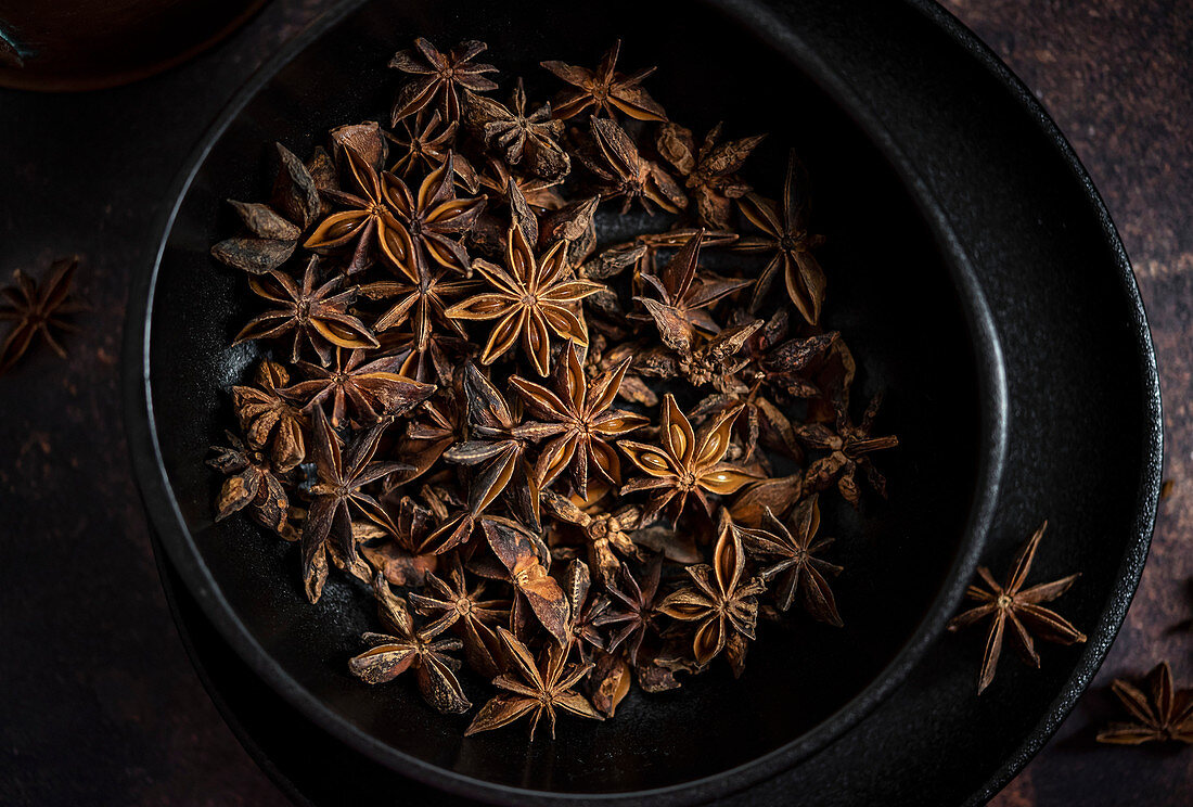 Star anise pods in a black plate