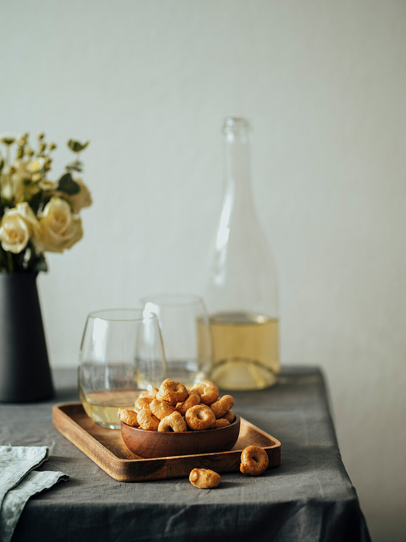 Traditional italian snack tarallini with white wine on table