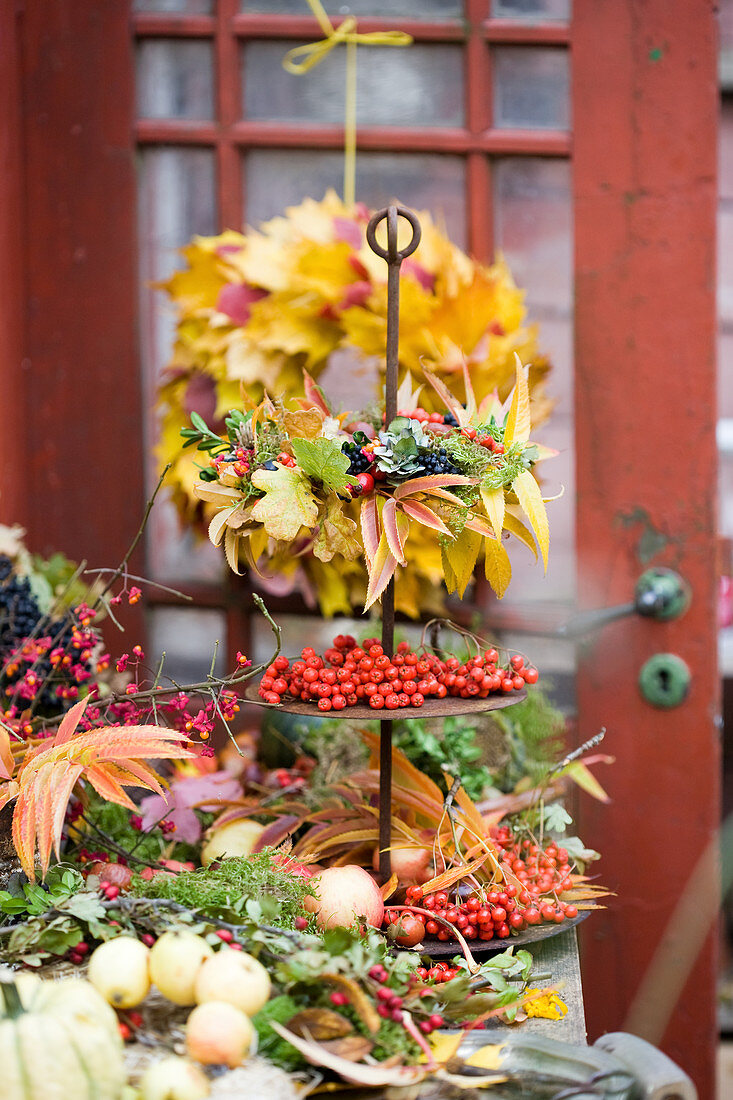 Etagere mit Herbstkranz aus Herbstlaub und Beeren