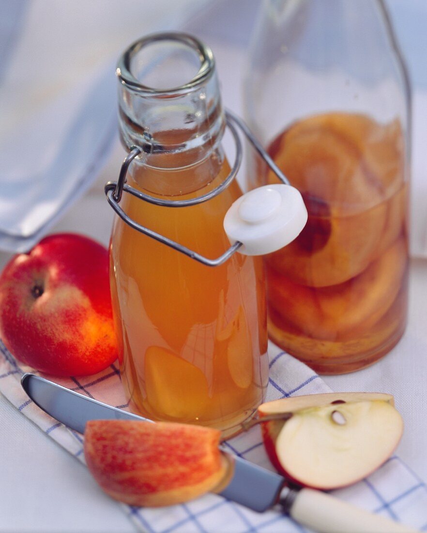 Apple Vinegar in a Glass Bottle with Fresh Apples