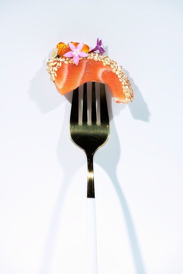 Lachs-Sashimi mit Kaviar und Essblüten auf Gabel