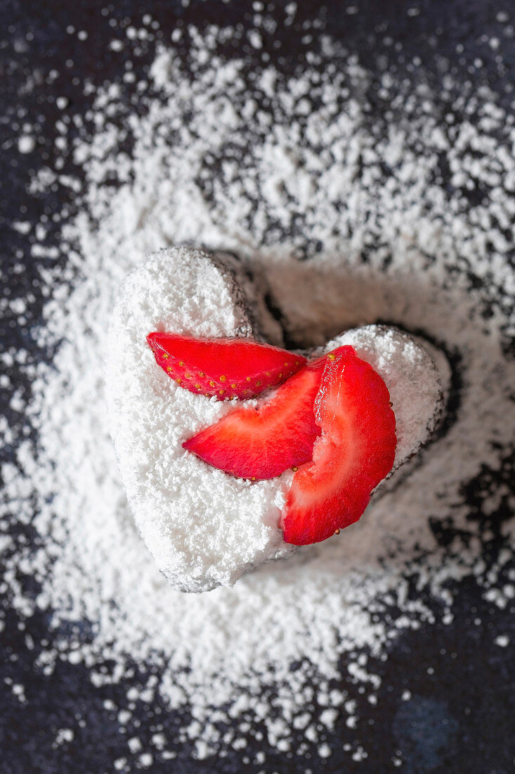Heart shaped brownie with icing sugar and strawberry